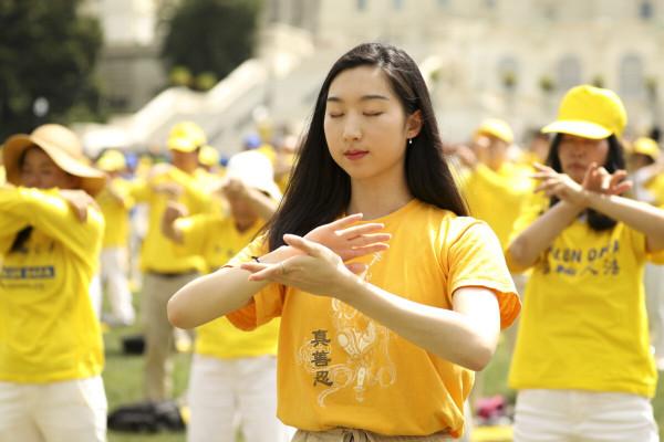 Les pratiquants de Falun Gong effectuant les exercices sur la pelouse ouest du Capitole, lors d’un rassemblement commémorant le 20e anniversaire de la persécution du Falun Gong en Chine, le 18 juillet 2019. (Image : Samira Bouaou / ET)