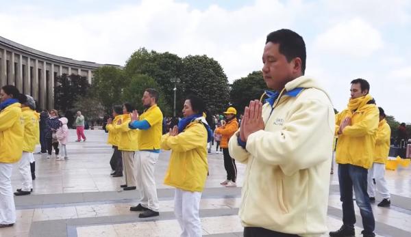 Un groupe de pratiquants de Falun Gong de France, faisant les exercices en plein air le 13 mai, lors de la Journée mondiale du Falun Dafa. (Image : Capture d’écran / YouTube)