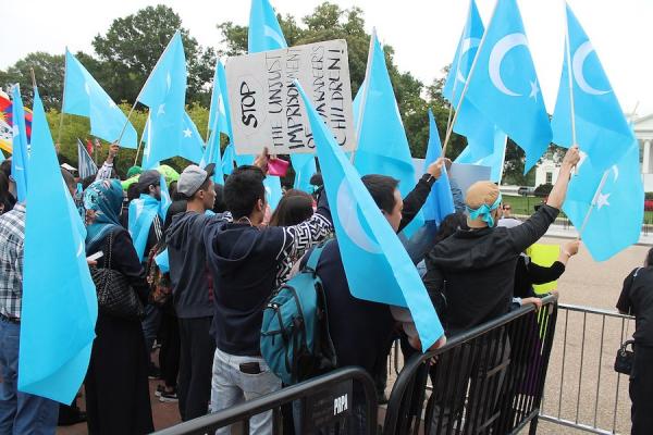 Des manifestants se tiennent derrière une exposition de photographies d’éminents intellectuels ouïghours détenus en Chine, lors d’un rassemblement au cours de la journée d’action mondiale « Resist China » (#ResistChina), une campagne mondiale contre le régime du parti communiste chinois. (Image : wikimedia / Elvert Barnes / CC BY-SA 2.0)