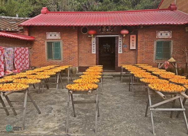 Un groupe de visiteurs danse et chante devant l’enceinte traditionnelle Hakka de la ferme. (Image : Billy Shyu / Vision Times)