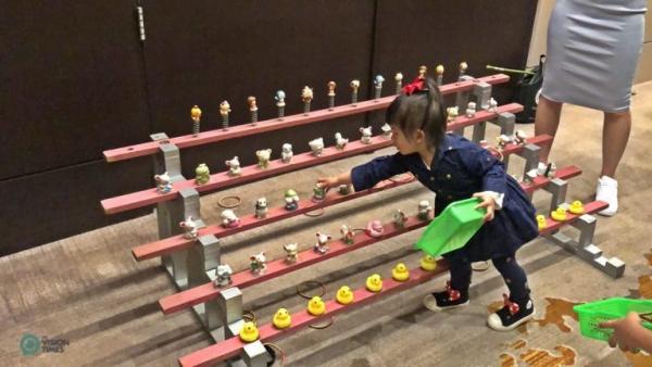 Un enfant joue au jeu du lancer d’anneau lors d’un dîner de retrouvailles du Nouvel An dans un hôtel de la ville de New Taipei. (Image : Billy Shyu / Vision Times) 