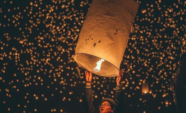 Lâcher une lanterne dans le ciel avec des souhaits écrits dessus pour la nouvelle année à venir. (Image : unsplash.com / @ Austin Neill)